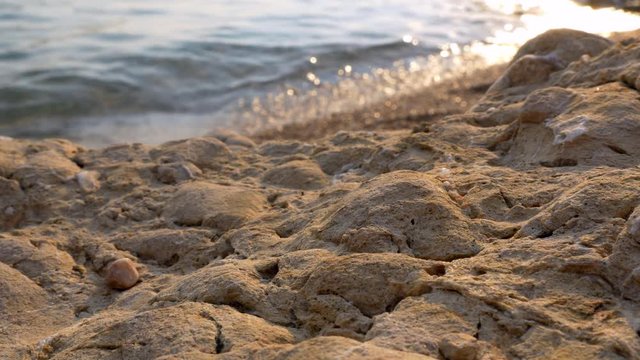 Closeup - Sandy rock eroded in a beach at sunset