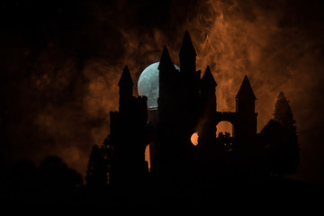 Mysterious medieval castle in a misty full moon. Abandoned gothic style old castle at night