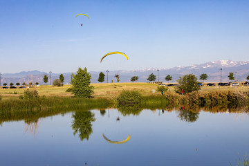 Paraglider flying over lake