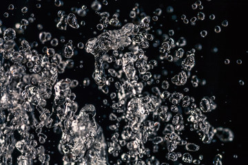 Many water drops frozen in an air on dark background
