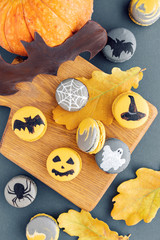 Halloween scary cookies with pumpkin on wooden cut board. pattern Bat , patina, ghosts and spiders. Gray color background, top view