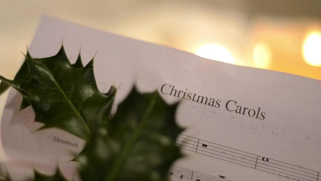 Christmas Carol Music Sheet with Candles and Holly