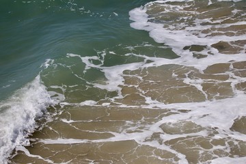 ocean water and sand mixing in the surf 