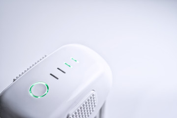 A white drone smart Battery pack with LED indicator lights ON, on white isolated background