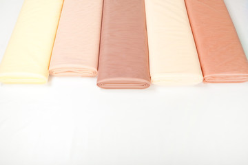 rolls of fabric lie on a white background. gradient beige
