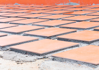 row tile ceramic orange on floor install with cement in work construction renovation outdoor home