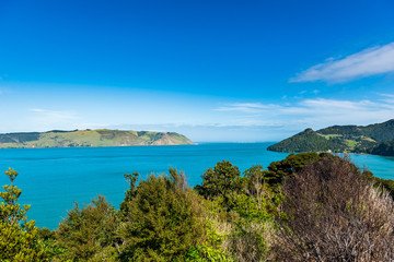 Obraz premium View of blue waters across a bay under a bright blue sky with some clouds