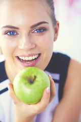 Close up portrait of healthy smiling woman with green apple.