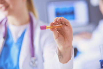 Laboratory assistant holding test tube, Close-up view focused on the test tube.