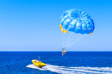 Blue parasail wing pulled by a boat. Sea summer recreation  - Cyprus. - Powered by Adobe