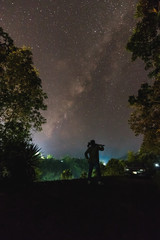 Silhouette of a cameraman will shooting a milky way