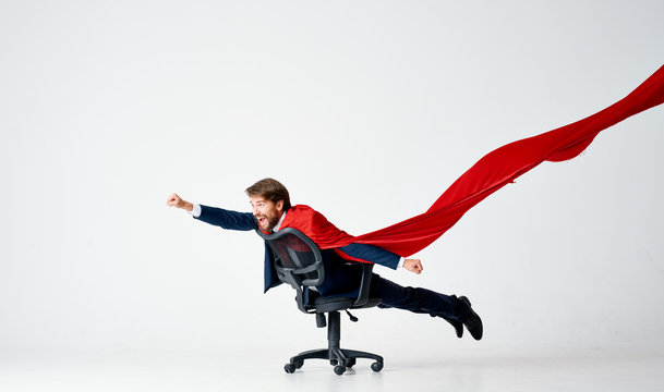 hero business man riding a chair in a red cloak on an isolated background superman