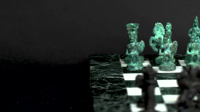 ancient marble chessboard with teal bronce knights as pawns slider macro