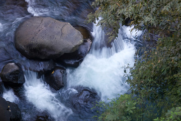 Stones in a flowing river close up. A beautiful nature background