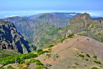 Naklejka premium Tourists near the top of Pico do Arieiro one of the highest peaks in Madeira island. Hiking trail from Pico do Arieiro to Pico Ruivo. 