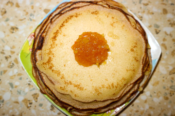 Tasty homemade pancakes with the orange jam on the plate