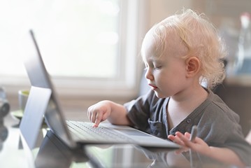 Baby playing with laptop computer