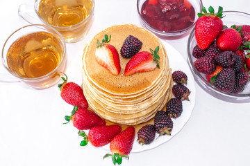 Delicious breakfast. Pancakes with fruit, strawberries and blackberries (mora) pour syrup (honey)...