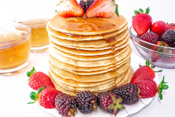 Tasty breakfast. Pancakes with fruit, strawberries and blackberries (mora) pour syrup (honey) on a...