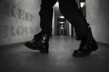 Men's Leather High Combat Boots In A Long Hallway With Text Keep Rockin' On The Wall