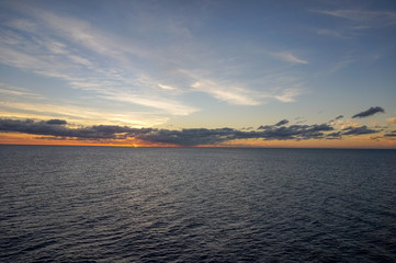 Sunset over the sea obscured by clouds