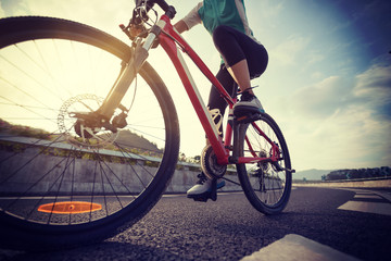 Fototapeta na wymiar Woman cyclist riding Mountain Bike on highway