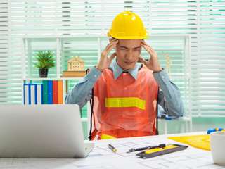 Young Asian man architect working at working desk about his housing project.