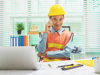 Young Asian man architect working at working desk about his housing project.