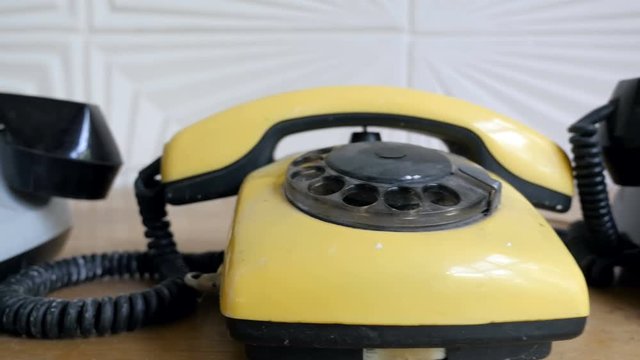 Slider view of vintage rotary dial phones covered by dust
