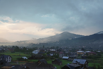 Picturesque view of mountain village with fog