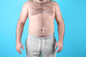 Fat man on color background, closeup. Weight loss
