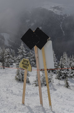 Double Black Diamond Sign At Ski Resort With Snow Covered Evergreens In The Background