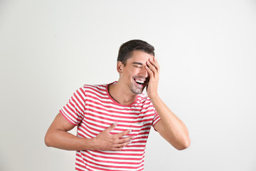 Portrait of handsome young man laughing on white background