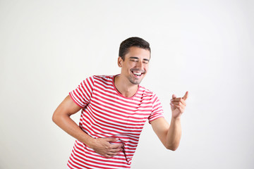 Fototapeta premium Portrait of handsome young man laughing on white background