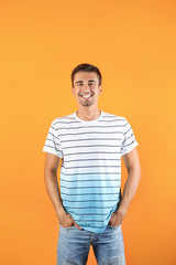 Portrait of handsome young man smiling on color background