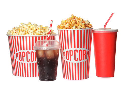 Delicious fresh popcorn and cups with beverages on white background