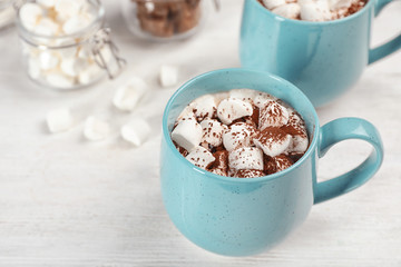 Cup of chocolate milk with marshmallows on wooden table
