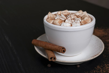 Tasty hot chocolate with milk and marshmallows in cup on table
