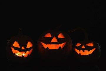 Halloween pumpkin heads. Glowing jack lanterns in dark