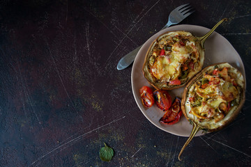 Autumn food with fresh vegetables, quick lunch: eggplant stuffed with tomatoes and cheese. The...