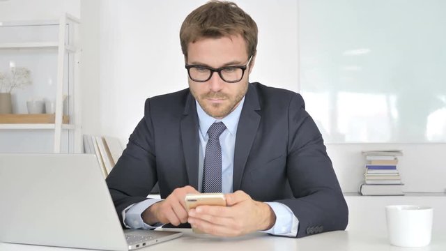 Businessman Using Smartphone at Work