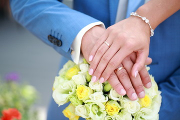 Obraz na płótnie Canvas hands of the newlyweds on the wedding bouquet