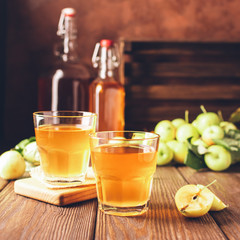  Apple cider, a drink of fresh ripe apples in a glass beaker on a dark wooden background. Fruit homemade wine. Autumn concept. Foreground. Copy space. Soft focus.