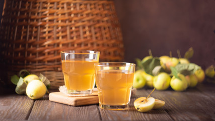 Apple drink homemade wine from ripe fruit in a glass goblet. Dark wooden background. Soft focus. Copy space. Place for design.