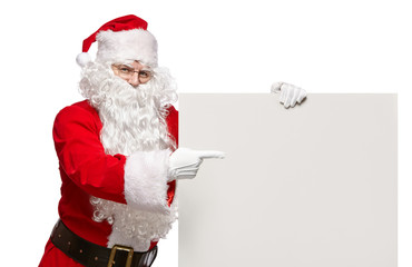 Happy Santa Claus points to a blank banner with to copy space.