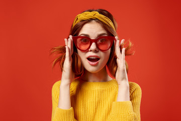 women wearing glasses in white sweater on a red background