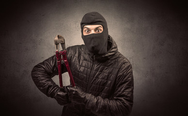Burglar standing in black clothes and balaclava on his head.