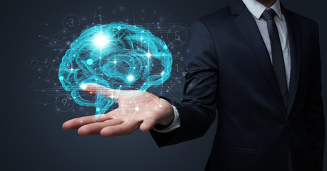 Businessman holding human brain on his hand with logistics symbols around