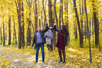 Fototapeta premium People, family and leisure concept - happy family with daughter walking in autumn park