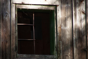 Fototapeta na wymiar Fenster einer verwitterten Hütte (alt / detail) / window in an old wooden house